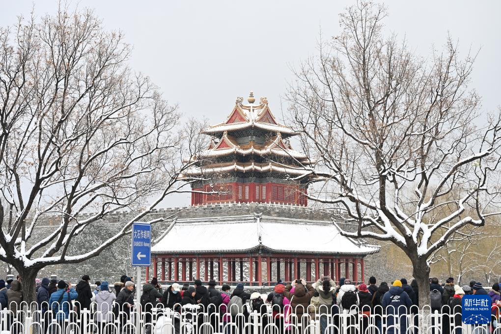 游客冒雪在故宫角楼前拍摄